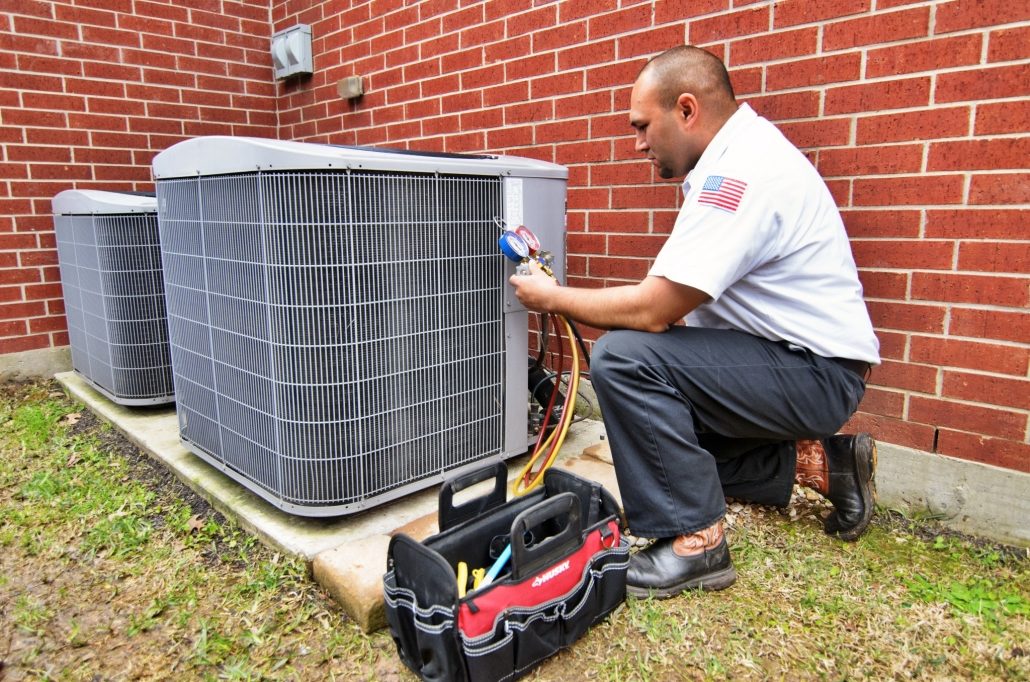 HVAC technician performing a tune-up on an outdoor AC unit
