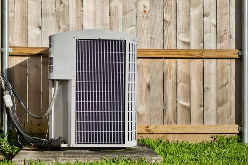 AC unit outside Michigan home against a wooden fence